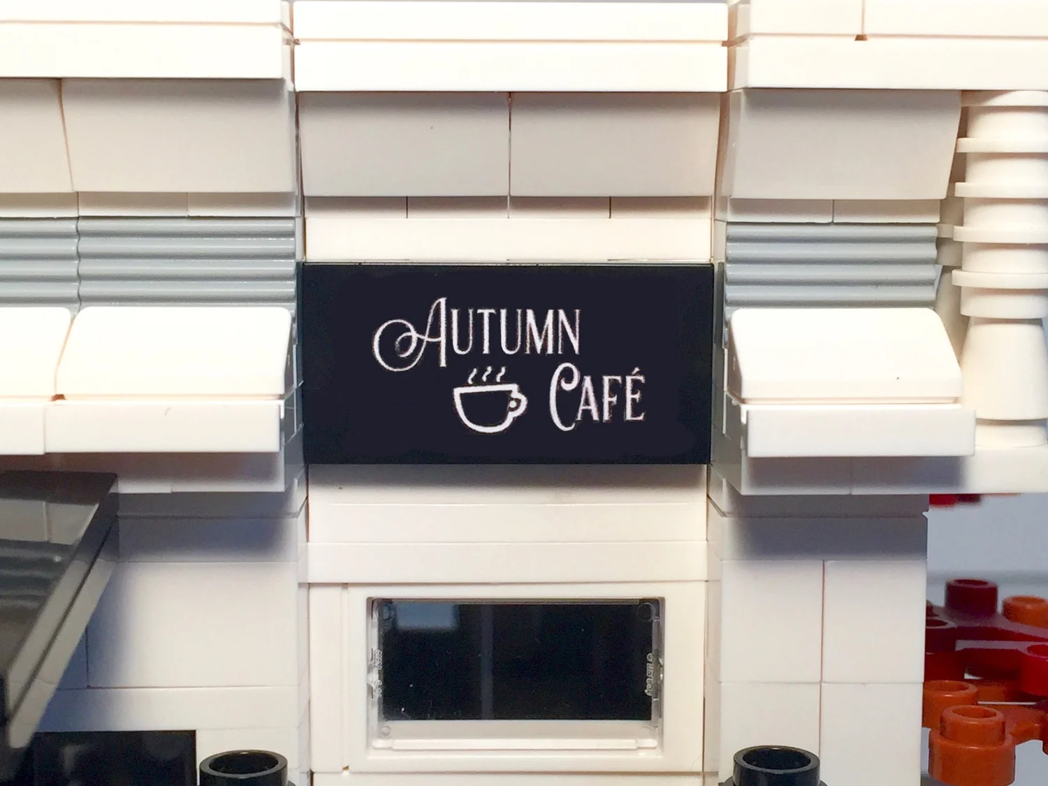 Close-up of the custom Autumn Café sign on the front of the LEGO building